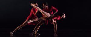 Three dancers in red outfits