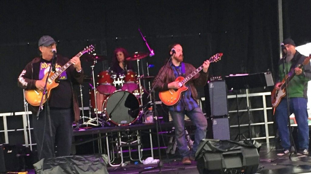 Four musicians playing music on a stage.