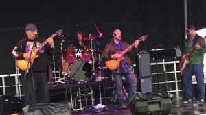 Four musicians playing music on a stage.